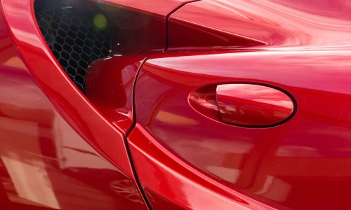 A closeup shot of the door handle of a modern red car
