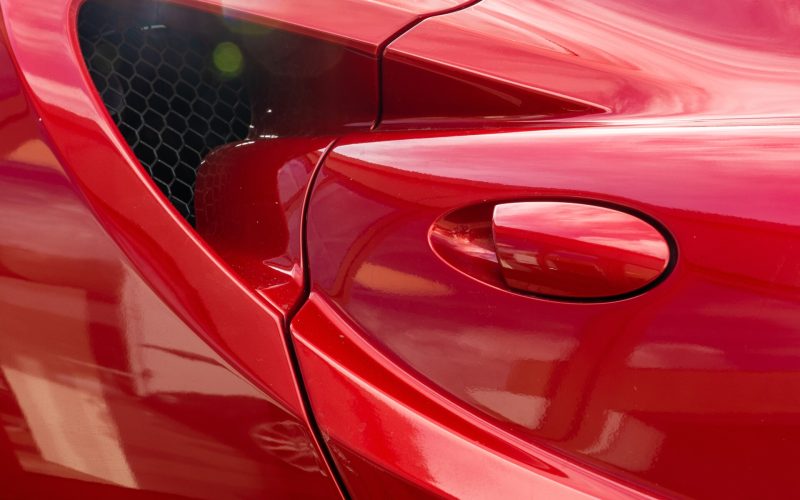 A closeup shot of the door handle of a modern red car